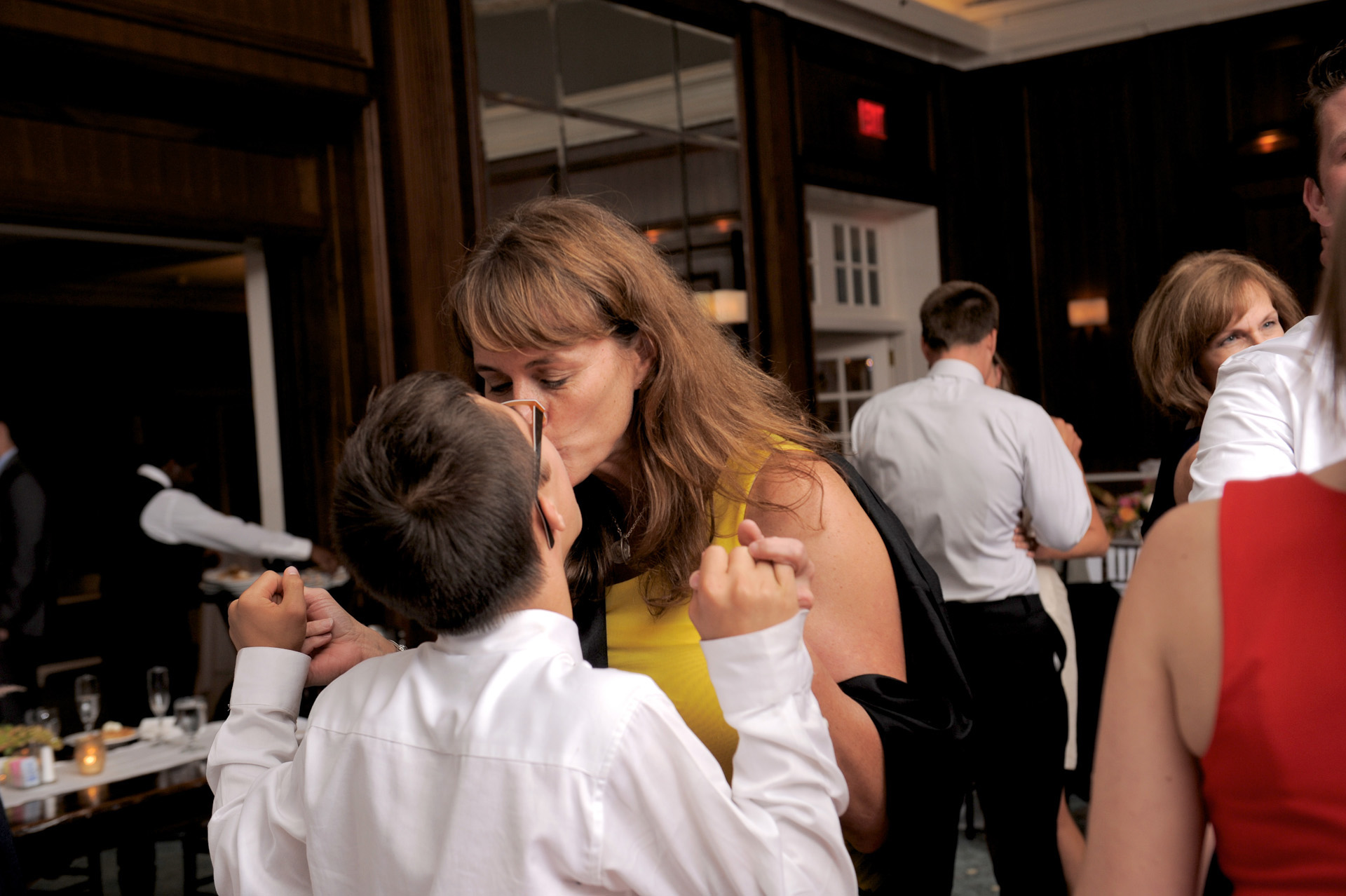 Detroit Golf Club wedding photographer's photo of ring bearer getting a kiss from his mother at the Detroit Golf Club.